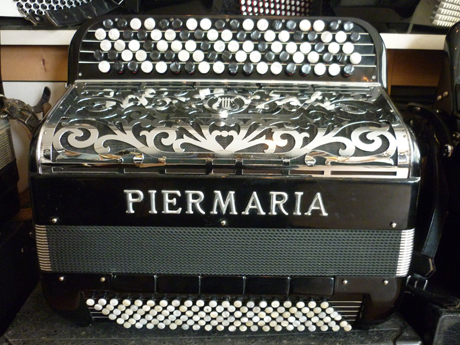 Accordeon Piermaria Super Regent double boite de resonance Un bel exemple de qualité issu des établissements Piermaria. Equivalent du Vedette dix d’une marque concurrente, cet accordéon possède une très belle palette de nuances, ainsi qu’un excellent volume sonore, grâce à ses anches faites à la main de la plus belle qualité, et montées clouées sur liège avec de magnifiques sommiers. Les matériaux rigoureusement sélectionnés lui confèrent une dynamique remarquable. il chante dans toutes les nuances du spectre. Et joue presque tout seul. Les caisses sont de type français, montées sur trois rangées de soupapes. La tessiture main droite est de cinquante cinq notes de DO à SOL, sur quatre voix, 16 8 8 4, basson deux flutes piccolo. Le basson et le piccolo sont dans la boite de résonance. il comporte dix registres derrière un clavier équipé de cinq rangs, aux boutons non cerclés dont les touches d’altérations sont noircies afin d’en faciliter le repérage. Cet accordéon de qualité professionnelle, possède un timbre des plus intéressants, pour le plus grand bonheur du musicien, ainsi que de son auditoire. Particulièrement bien entretenu par le précédent propriétaire, les caisses présentent néanmoins quelques traces d’usage, ceci augure un bon rodage. L’accordage du brio est américain atténué, le diapason est à 442 Hz. La caisse des basses comporte cinq registres, et cinq voix, dont la note grave est MI. les anches sont faites à la main de la marque Antonelli. La mécanique comporte deux rangées aux basses, quatre rangées aux accords, ce qui offre les accords septième diminués. Ceci est plutôt rare sur ce type de modèle, et permet de pratiquer des accords typés jazz. A venir écouter voir.  Tous les  accordéons vendus par Accord Deléon sont accordé à neuf. Pourvus d’un jeu de bretelles housse ou étui neufs. Assortis d’un service après vente offrant garantie et qualité